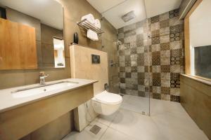 bagno con servizi igienici, lavandino e specchio di Aurora Hotels and Resorts a Pulickamaly