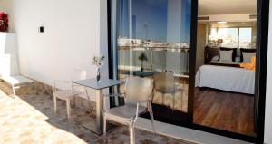 een kamer met een tafel en stoelen en een slaapkamer bij Hotel Don Paco in Sevilla