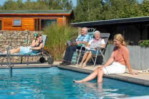 um grupo de pessoas sentadas ao redor de uma piscina em Bed & Breakfast Trouwborst em Rhenen