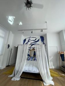 een slaapkamer met een bed met gordijnen erop bij Le Loft du Homard Bleu à Saint-Malo Intra-Muros in Saint-Malo