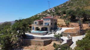 une image d'une maison avec une colline dans l'établissement Drys Villas Mekoynida, à Karistos