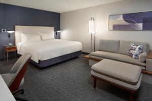 une chambre d'hôtel avec un lit et un canapé dans l'établissement Courtyard by Marriott Toronto Markham, à Markham