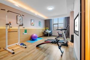 einen Fitnessraum mit Trainingsgeräten in einem Zimmer in der Unterkunft Kunming Spring City Boutique Hotel in Kunming