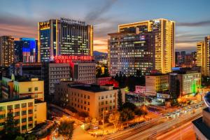 Blick auf eine Stadt in der Nacht mit Gebäuden in der Unterkunft Kunming Spring City Boutique Hotel in Kunming