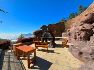 un patio con panchine e griglia con rocce di Chandys Drizzle Drops - Munnar Top Station a Munnar