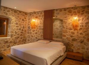 a bedroom with a white bed with two pillows at Zoe Hora in Dhërmi