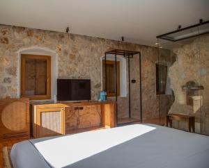 a bedroom with a bed and a tv on a wall at Zoe Hora in Dhërmi