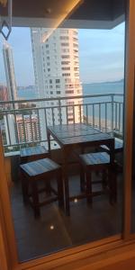 a table and benches on a balcony with a view at 1bedroom seaview ห้องวิวทะเล ชั้น28 premium highfloorวิ in Jomtien Beach