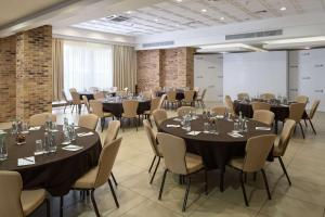 a conference room with tables and chairs and a projection screen at Radisson Blu Hotel, Kyiv Podil City Centre in Kyiv