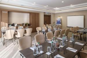 a conference room with tables and chairs and a screen at Radisson Blu Hotel, Kyiv Podil City Centre in Kyiv