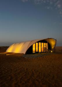 una tienda en medio del desierto por la noche en La Duna Desert Camp, en Shāhiq