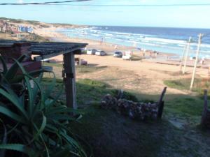 Blick auf einen Strand mit einem Haus und das Meer in der Unterkunft La Posada in Punta Del Diablo