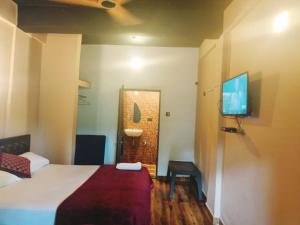 a hotel room with a bed and a television at Beach Deluxe Carolina GuestHouse & VIlla in Colva