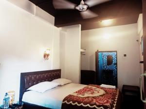 a bedroom with a large bed with a red and blue blanket at Beach Deluxe Carolina GuestHouse & VIlla in Colva