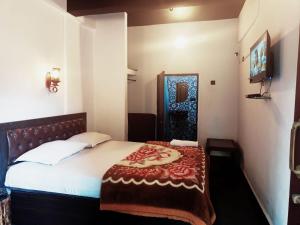 a bedroom with a bed with a red blanket on it at Beach Deluxe Carolina GuestHouse & VIlla in Colva