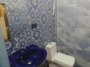 a bathroom with a blue toilet and a sink at Beach Deluxe Carolina GuestHouse & VIlla in Colva