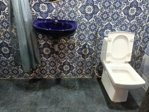 a bathroom with a toilet and a blue sink at Beach Deluxe Carolina GuestHouse & VIlla in Colva