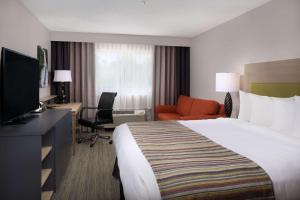 een hotelkamer met een bed, een bureau en een televisie bij Country Inn & Suites by Radisson, Portland International Airport, OR in Portland