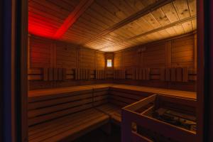 een houten sauna met rood licht bij Hotel Arnika in Pozza di Fassa