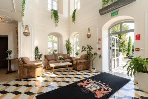 a living room with leather chairs and a couch at Royal Hotel Modlin in Nowy Dwór Mazowiecki