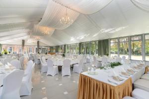 a banquet hall with white tables and white chairs at Royal Hotel Modlin in Nowy Dwór Mazowiecki