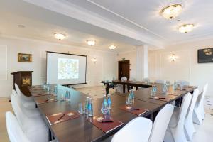 a large meeting room with a long table and white chairs at Royal Hotel Modlin in Nowy Dwór Mazowiecki