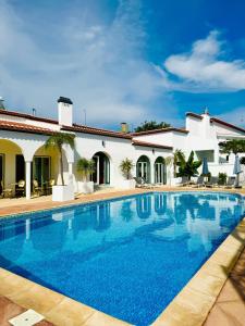 a swimming pool in front of a villa at SOLAR DOS FRADES in Ferreira do Alentejo