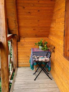 a table and a chair in a wooden cabin at Tisnyi 7 Guest House in Kamianets-Podilskyi