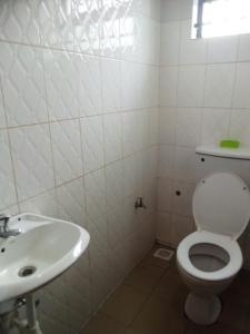 La salle de bains est pourvue de toilettes et d'un lavabo. dans l'établissement Annonceur Guest House, à Kampala