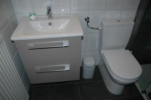 a bathroom with a white sink and a toilet at Hotel Kappelner Hof in Kappeln