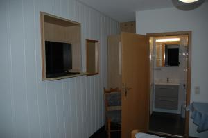 a room with a television on the wall and a bathroom at Hotel Kappelner Hof in Kappeln