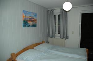 a bed in a bedroom with a picture on the wall at Hotel Kappelner Hof in Kappeln