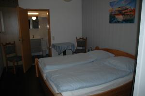 a small bedroom with a bed and two chairs at Hotel Kappelner Hof in Kappeln