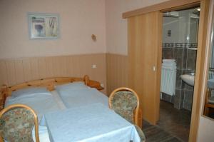 a bedroom with a bed and a bathroom with a sink at Hotel Kappelner Hof in Kappeln