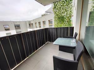 een patio met een tafel en stoelen op een balkon bij JR Smolna in Poznań