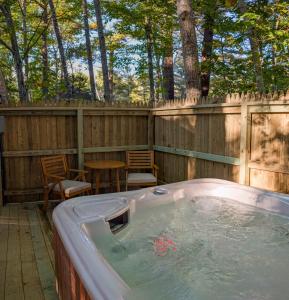 einen Whirlpool im Hinterhof mit einem Holzzaun in der Unterkunft Hinckleys Dreamwood Cottages in Bar Harbor