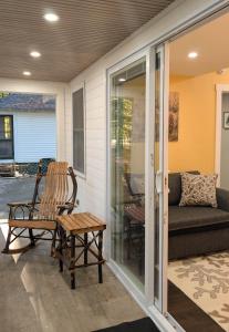 eine abgeschirmte Veranda mit einem Stuhl und einem Sofa in der Unterkunft Hinckleys Dreamwood Cottages in Bar Harbor