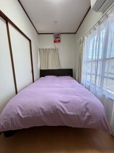 浦安URAYASU HOUSE! for up to 6 people, 15 min bus ride to Disney! Location is 6-8-38 Horie Urayasu City Chiba Prefecture 場所は千葉県浦安市堀江6-8-38です,玄関横のキーボックスの暗証番号はご予約後に宿からのメッセージ欄にてご確認下さい的一间卧室配有一张紫色床和窗户