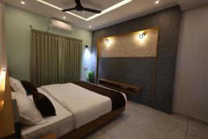 a bedroom with a bed and a wall with lights at Riders Den in Mananthavady