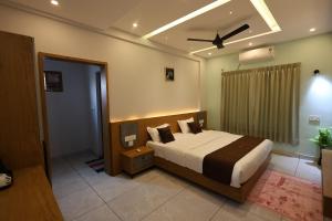 a bedroom with a bed and a ceiling fan at Riders Den in Mananthavady