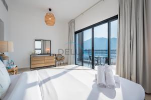 a bedroom with a bed with a view of the ocean at Serene Island Getaway 3BR Villa with Assistant Room Al Dana Island, Fujairah by Deluxe Holiday Homes in Fujairah