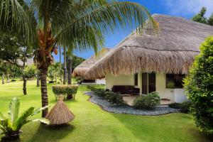 une maison avec un toit de chaume et une cour dans l'établissement Atmosphere Resorts & Spa, à Dauin