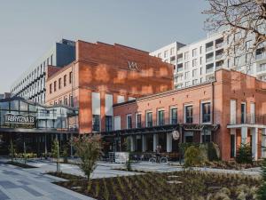 un bâtiment en brique dans une rue de la ville avec de grands bâtiments dans l'établissement Mercure Krakow Fabryczna City, à Cracovie