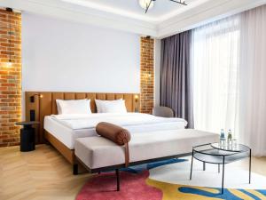 - une chambre avec un lit king-size et une table dans l'établissement Mercure Krakow Fabryczna City, à Cracovie