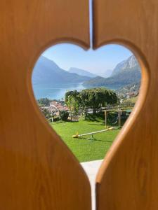 een hartvormig raam met uitzicht op een park bij Villa la Dama del Lago in Molveno