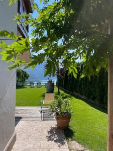 een patio met een bank en uitzicht op het water bij Villa la Dama del Lago in Molveno