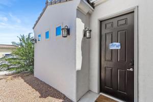 una puerta de una casa blanca con un cartel en ella en Cozy Casita Suite, en Las Cruces