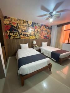 2 Betten in einem Zimmer mit Wandbild in der Unterkunft Yours Hotel Lifestyle in Chiclayo