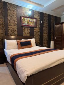 um quarto com uma cama grande e papel de parede preto e dourado em Hotel Islamabad Premiere Inn em Islamabad