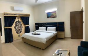 um quarto com uma cama grande e uma cortina azul em Dream Inn Guest House em Islamabad